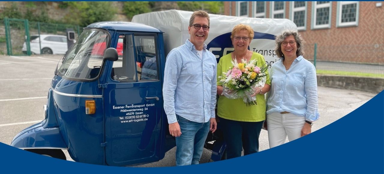 Frau & Herr Mathew stehen mit Frau Schlipköther vor der EFT Ape